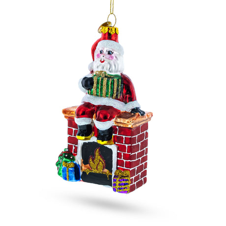 Cozy Santa Sitting on Fireplace Glass Christmas Ornament in Multi color