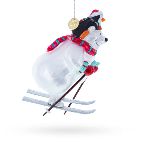 Skiing Polar Bear with Penguin Blown Glass Christmas Ornament , dimensions in inches: 5.1 x 2.2 x 3.2