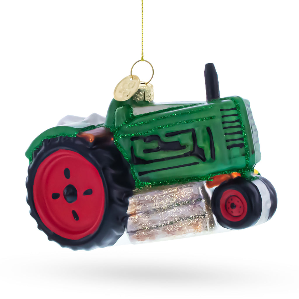 Green Tractor with Crop Barrels Glass Christmas OrnamentChina , dimensions in inches: 3.1 x 2.6 x 4.2