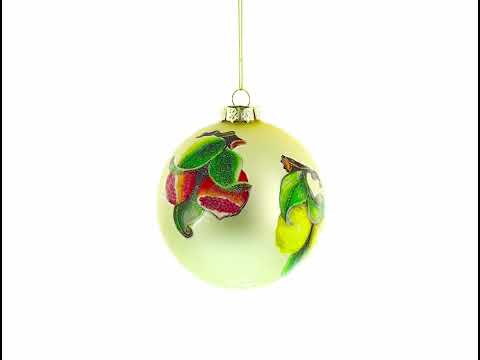 Adorno navideño de cristal con limones y granadas en una rama