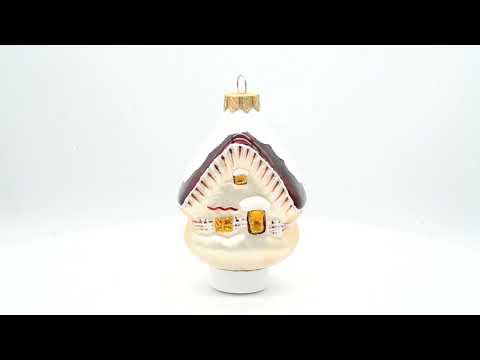 Haus mit schneebedecktem Dach, gläserne Weihnachtsornamente