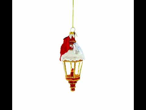 Roter Kardinal sitzt auf einer Laterne aus Glas als Weihnachtsschmuck