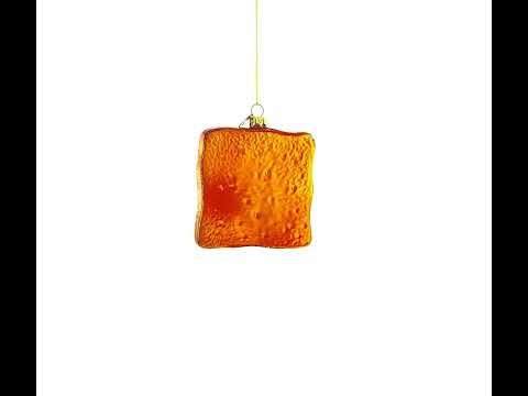 Adorno navideño de cristal con forma de huevo sobre pan tostado