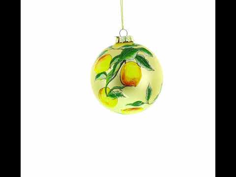 Adorno navideño de cristal con limones en la rama de un árbol